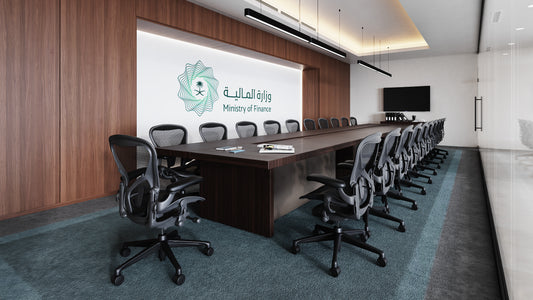 Modern boardroom at the Ministry of Finance with a long wooden conference table, ergonomic chairs, wall-mounted screen, and the Ministry of Finance logo – قاعة اجتماعات حديثة في وزارة المالية تحتوي على طاولة مؤتمرات خشبية طويلة وكراسي مريحة وشاشة مثبتة على الجدار مع شعار وزارة المالية 1