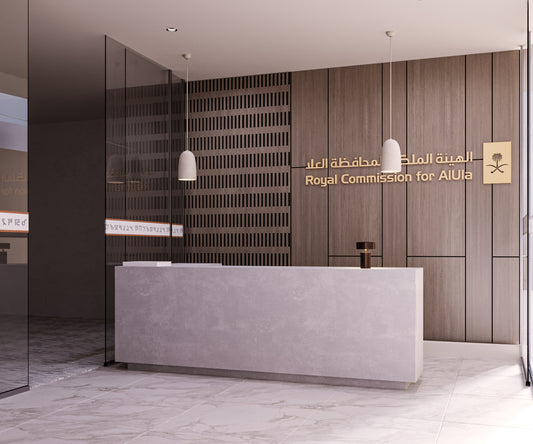 Modern reception desk at Royal Commission for AlUla office, designed with a minimalist stone counter, wooden wall cladding, and pendant lights – a premium interior solution by Atelier 21 KSA. Best interior fit-out in Riyadh and Saudi Arabia, combining elegance and functionality for government and corporate spaces – مكتب استقبال حديث في الهيئة الملكية لمحافظة العلا بتصميم راقٍ من مفن الرسام مع مكتب حجري وجدران خشبية وإضاءة معلقة. افضل شركة تشطيبات داخلية في الرياض والسعودية. 4