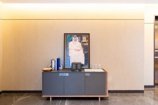 Modern office corner with a portrait, decorative books, and a minimalist cabinet, designed by Atelier 21 KSA, top interior designer in Saudi Arabia – زاوية مكتب عصرية تحتوي على صورة شخصية، كتب ديكورية، وخزانة بسيطة من تصميم مفن الرسام، أفضل مصمم داخلي في السعودية 5