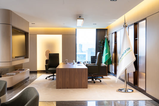 Modern executive government office with wooden desk, leather chairs, Saudi flags, and built-in cabinetry by Atelier 21 KSA, top interior designer in Saudi Arabia – مكتب حكومي تنفيذي عصري يحتوي على مكتب خشبي، كراسي جلدية، أعلام السعودية، وخزائن مدمجة من تصميم مفن الرسام، أفضل مصمم داخلي في السعودية 6