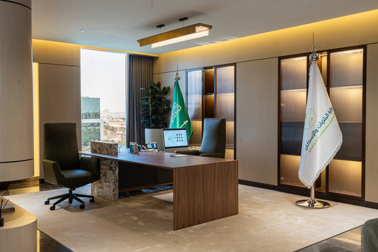 Modern executive office with wooden desk, leather chairs, Saudi Ministry flags, and built-in wall lighting by Atelier 21 KSA, top interior designer in Saudi Arabia – مكتب تنفيذي عصري يحتوي على مكتب خشبي، كراسي جلدية، أعلام وزارة الشؤون البلدية والقروية، وإضاءة مدمجة بالحائط من تصميم مفن الرسام، أفضل مصمم داخلي في السعودية 8