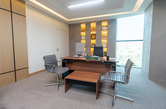 Modern executive office with wooden desk, leather chairs, built-in wall shelving with awards, and large window by Atelier 21 KSA, top interior designer in Saudi Arabia – مكتب تنفيذي عصري يحتوي على مكتب خشبي، كراسي جلدية، رفوف حائط مدمجة تعرض جوائز، ونافذة كبيرة من تصميم مفن الرسام، أفضل مصمم داخلي في السعودية 16