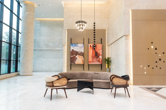 Modern lobby of an office lobby with beige sofa, rattan chairs, decorative lighting, and wall art by Atelier 21 KSA, top interior designer in Saudi Arabia – بهو وزارة عصري يحتوي على كنبة بيج، كراسي بقوائم خشبية، إضاءة ديكورية، ولوحات فنية من تصميم مفن الرسام، أفضل مصمم داخلي في السعودية 33