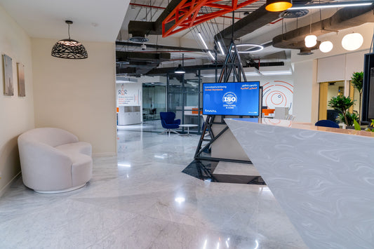 Tawal reception area featuring a bold angular desk in white marble finish, a modern lounge with accent chairs, backlit signage, and dynamic lighting—designed for both function and aesthetics by Atelier 21, top interior firm in Saudi Arabia.
منطقة استقبال تــوال بتصميم عصري يضم مكتب استقبال بزاوية حادة بتشطيب رخامي أبيض، مع كراسي استراحة أنيقة، إضاءة ديناميكية ولافتات مضيئة – تنفيذ مفن الرسام، أفضل شركة تصميم داخلي في السعودية. 19