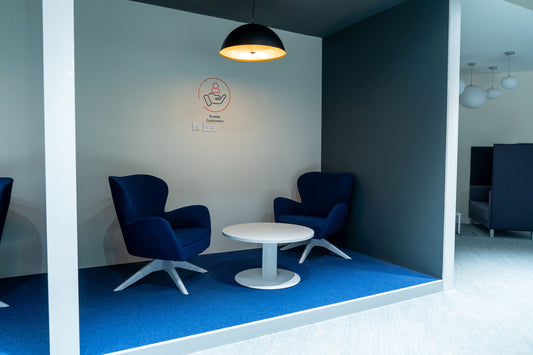 Cozy breakout zone with two deep blue lounge chairs and a round white coffee table, ideal for casual meetings or relaxed conversations—set against a modern backdrop with soft lighting. Designed by Atelier 21, a top interior design company in Saudi Arabia.
منطقة استراحة أنيقة تضم كرسيين بلون أزرق داكن وطاولة بيضاء مستديرة، مثالية للاجتماعات غير الرسمية أو المحادثات الودية – تصميم عصري بإضاءة ناعمة – من تنفيذ مفن الرسام، أفضل شركة تصميم داخلي في السعودية. 18