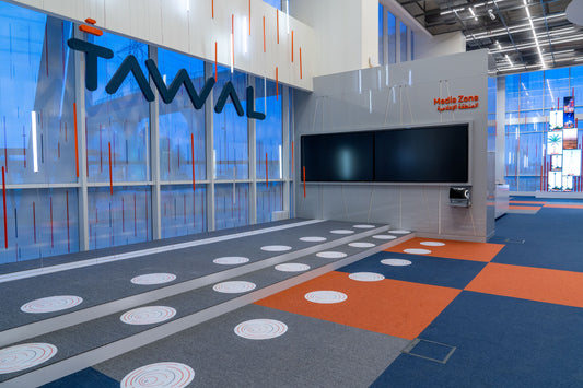 Tawal Media Zone in Riyadh – futuristic and interactive space featuring digital screens, bold ceiling details, and patterned flooring with vibrant graphics – designed to engage and inform visitors – executed by Atelier 21 KSA, Top Interior Fit-out Company in Saudi Arabia and Riyadh. منطقة الإعلام في TAWAL – تصميم عصري تفاعلي بشاشات رقمية وعناصر هندسية مميزة وأرضيات ملونة – تنفيذ مفن الرسام، أفضل شركة تصميم داخلي وتنفيذ في السعودية والرياض. 2