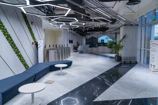 Modern reception and security gate area featuring hexagonal ceiling lights, marble flooring, integrated greenery, and minimal lounge seating – designed by Atelier 21 KSA, Top Interior Fit-out Company in Saudi Arabia and Riyadh.
منطقة استقبال حديثة وبوابات أمنية بإضاءة سقفية سداسية، أرضيات رخامية، لمسات خضراء مدمجة، ومقاعد استراحة بسيطة – من تنفيذ مفن الرسام، أفضل شركة تصميم داخلي وتشطيب مكاتب في السعودية والرياض. 6