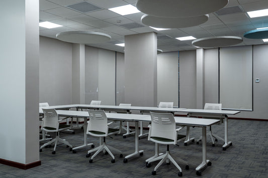 Training room at the Welaya project in Riyadh, featuring white modular training tables and ergonomic chairs on wheels, arranged in a U-shape. The space includes modern acoustic ceiling panels and grey carpet flooring, offering a practical and flexible learning environment. غرفة تدريب حديثة في مشروع ولاية بالرياض تضم طاولات تدريب بيضاء وكراسي مريحة، تصميم مرن وأرضيات سجادية، مع ألواح صوتية بالسقف لراحة المستخدمين. 5