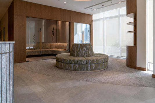 Elegant lobby lounge at Azm Saudi Project, featuring a circular upholstered seating area, modern wooden finishes, and glass partitions for a welcoming corporate design. Executed by a Top Interior Designer in Riyadh and furnished by a Top Office Furniture Supplier in Saudi Arabia, the space blends luxury with functionality. ردهة استقبال أنيقة في مشروع عزم السعودية من تصميم أفضل مصمم داخلي في السعودية وتشطيب من أفضل شركة تنفيذ تشطيبات داخلية في الرياض. 7