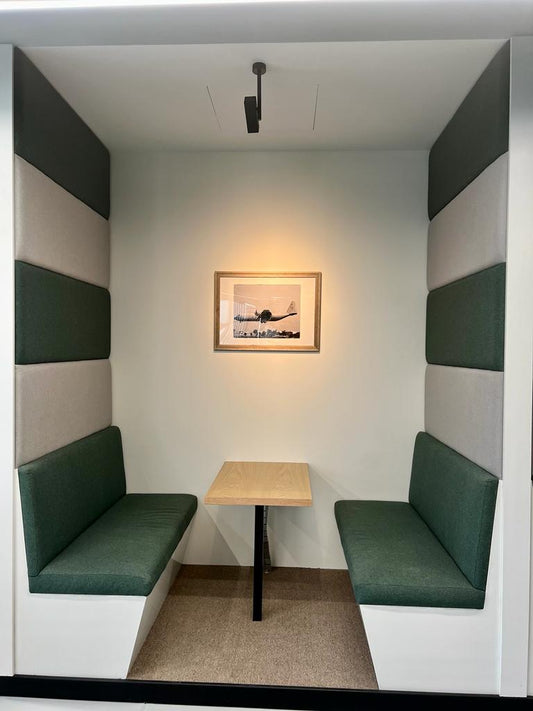 Private acoustic meeting booth at GDC, one of the PIF companies, designed with upholstered green and grey panels and a minimalist wooden table – executed by Atelier 21 KSA, Top Interior Designer and Office Furniture Supplier in Saudi Arabia and Riyadh. كشك اجتماعات خاص في مشروع GDC إحدى شركات صندوق الاستثمارات العامة، بتصميم مبطن بألواح خضراء ورمادية وطاولة خشبية بسيطة، من تنفيذ مفن الرسام، كأفضل مصمم داخلي ومورد أثاث ومصمم مكاتب في السعودية والرياض 3