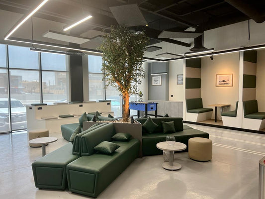 Breakout lounge designed for GDC, one of the PIF companies, featuring modular green seating, integrated planter, and acoustic ceiling panels – executed by Atelier 21 KSA, Top Interior Designer and Furniture Supplier in Saudi Arabia and Riyadh. مساحة استراحة عصرية في مشروع GDC إحدى شركات صندوق الاستثمارات العامة، بتصميم مرن ومقاعد خضراء وسقف بمعالجة صوتية من تنفيذ مفن الرسام، مما يعكس مكانته كأفضل مصمم داخلي ومورد أثاث في السعودية والرياض. 1