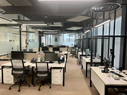 Modern open workspace at GDC, one of the PIF companies, featuring ergonomic workstations, glass partitions, and acoustic ceiling panels – designed by Atelier 21 KSA, Top Office Designer and Furniture Supplier in Saudi Arabia and Riyadh. مساحة عمل مفتوحة عصرية في مشروع GDC إحدى شركات صندوق الاستثمارات العامة، تضم محطات عمل مريحة وفواصل زجاجية وسقفاً معالجاً صوتياً من تنفيذ مفن الرسام، كأفضل مصمم مكاتب ومورد أثاث ومصمم داخلي في السعودية والرياض. 5