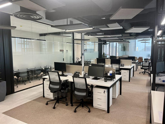 Spacious open office layout at GDC, one of the PIF companies, featuring ergonomic workstations, neutral tones, and suspended acoustic panels – delivered by Atelier 21 KSA, Top Interior Designer and Office Furniture Supplier in Saudi Arabia and Riyadh. تصميم مكتب مفتوح واسع في مشروع GDC إحدى شركات صندوق الاستثمارات العامة، يضم محطات عمل مريحة وألواناً هادئة وسقفاً معلقاً معالجاً صوتياً من تنفيذ مفن الرسام، كأفضل مصمم داخلي ومورد أثاث ومصمم مكاتب في السعودية والرياض. 7