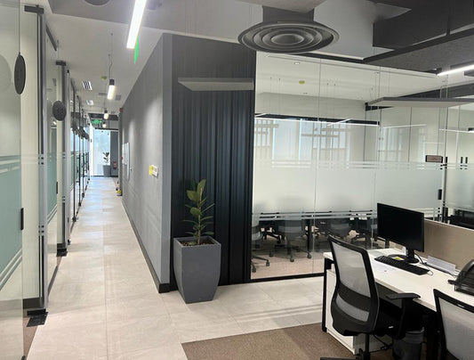 Sleek office corridor at GDC, one of the PIF companies, featuring frosted glass meeting rooms, suspended lighting, and modern flooring – designed and executed by Atelier 21 KSA, Top Office Designer and Interior Designer in Saudi Arabia and Riyadh. ممر مكتبي أنيق في مشروع GDC إحدى شركات صندوق الاستثمارات العامة، يضم غرف اجتماعات بزجاج بلوري وإضاءة معلقة وأرضيات حديثة من تنفيذ مفن الرسام، مما يعكس تميزه كأفضل مصمم داخلي ومورد أثاث ومصمم مكاتب في السعودية والرياض. 8