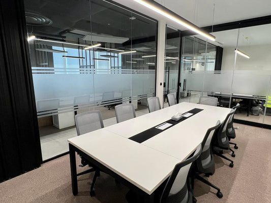 Minimalist meeting room at GDC, one of the PIF companies, designed with a white conference table, ergonomic chairs, and frosted glass walls for privacy – delivered by Atelier 21 KSA, Top Interior Designer and Office Furniture Supplier in Saudi Arabia and Riyadh. غرفة اجتماعات بسيطة في مشروع GDC إحدى شركات صندوق الاستثمارات العامة، تضم طاولة بيضاء وكراسي مريحة وجدران زجاجية بلورية من تنفيذ مفن الرسام، كأفضل مصمم داخلي ومورد أثاث ومصمم مكاتب في السعودية والرياض. 10
