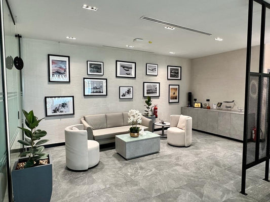 Reception lounge at GDC, one of the PIF companies, designed with neutral-toned seating, aviation wall art, coffee tables, and storage units – executed by Atelier 21 KSA, Top Interior Designer and Office Furniture Supplier in Saudi Arabia and Riyadh. صالة استقبال في مشروع GDC إحدى شركات صندوق الاستثمارات العامة، تضم مقاعد بلون حيادي ولوحات فنية بطابع الطيران وطاولات قهوة ووحدات تخزين من تنفيذ مفن الرسام، كأفضل مصمم داخلي ومورد أثاث ومصمم مكاتب في السعودية والرياض. 14