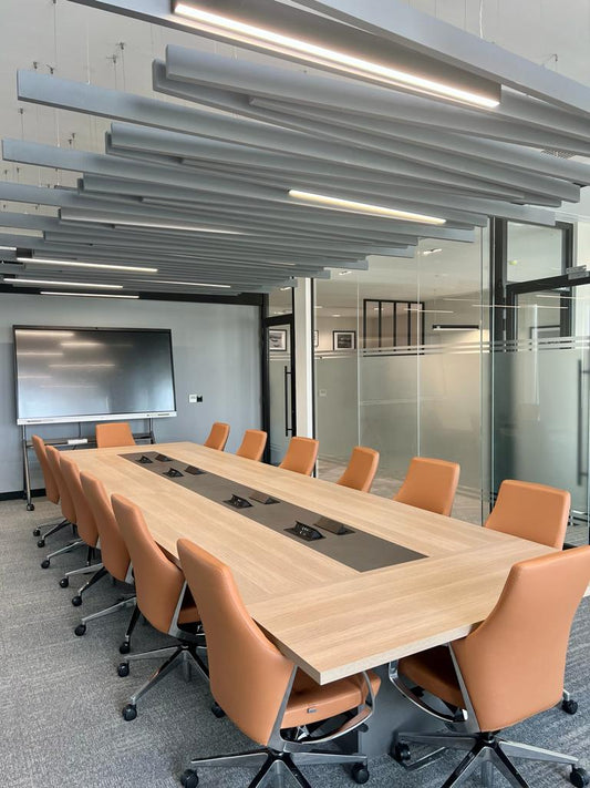 Contemporary boardroom interior featuring rich leather executive chairs, a sleek black conference table, and ceiling acoustic panels, designed by Atelier 21 KSA – Top Interior Designer and Office Furniture Supplier in Saudi Arabia and Riyadh. تصميم داخلي لغرفة اجتماعات عصرية تضم كراسي تنفيذية جلدية وطاولة سوداء أنيقة وسقف بمعالجة صوتية من تنفيذ مفن الرسام، مما يعكس تميز مفن الرسام كأفضل مصمم داخلي ومورد أثاث ومصمم مكاتب في السعودية والرياض. 12