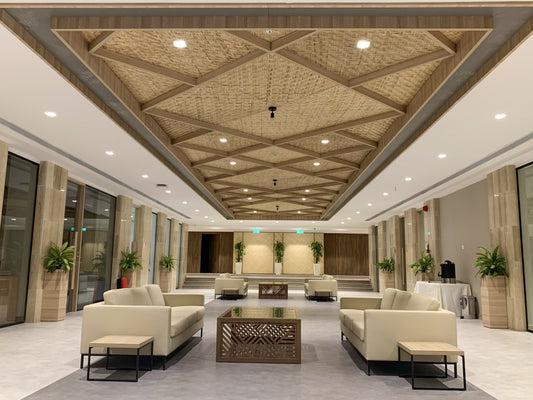 Elegant lobby with natural wood patterned ceiling, beige modern sofas, glass-top coffee tables, potted plants, and ambient lighting – designed and fitted by Atelier 21 KSA, Top Interior Designer, Office Designer, Furniture Supplier, and Interior Fit-out Company in Saudi Arabia and Riyadh. ردهة فاخرة بتصميم سقف خشبي ونباتات داخلية، تنفيذ مفن الرسام، أفضل شركة ديكور وتشطيب داخلي في السعودية والرياض. 10