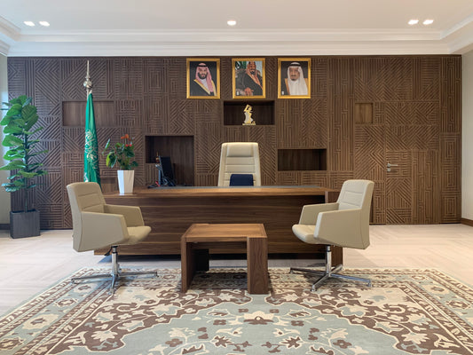 Executive office at The Saudi Irrigation Organization featuring custom wood paneling, leather seating, a national flag, and royal portraits – designed and delivered by Atelier 21 KSA, Top Interior Designer and Office Furniture Supplier in Saudi Arabia and Riyadh. مكتب تنفيذي في المؤسسة العامة للري، يتميز بجدران خشبية مصممة خصيصاً ومقاعد جلدية وعلم وطني وصور القيادة، من تنفيذ مفن الرسام، كأفضل مصمم داخلي ومورد أثاث ومصمم مكاتب في السعودية والرياض. 1
