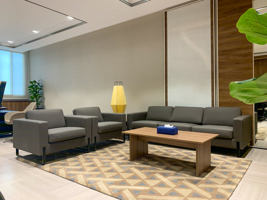 VIP lounge at The Saudi Irrigation Organization, featuring contemporary gray sofas, patterned area rug, wood-paneled walls, and a unique yellow floor lamp – furnished by Atelier 21 KSA, Top Interior Designer and Office Furniture Supplier in Saudi Arabia and Riyadh. صالة كبار الزوار في المؤسسة العامة للري، تضم أرائك رمادية حديثة وسجادة بأشكال هندسية وجدران خشبية ومصباح أرضي مميز، من تنفيذ مفن الرسام، كأفضل مصمم داخلي ومورد أثاث ومصمم مكاتب في السعودية والرياض. 3