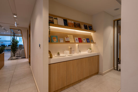 Cozy reading nook at Azm Saudi Project, featuring built-in wooden shelves with books, decorative items, and warm lighting, creating a welcoming office corner. Designed by a Top Interior Designer in Riyadh and executed by a Top Interior Fit-out Company in Saudi Arabia, it enhances workplace culture. زاوية مكتبة عصرية في مشروع عزم السعودية من عمل أفضل مصمم داخلي في السعودية وتشطيب من أفضل شركة تنفيذ تشطيبات داخلية في الرياض. 15