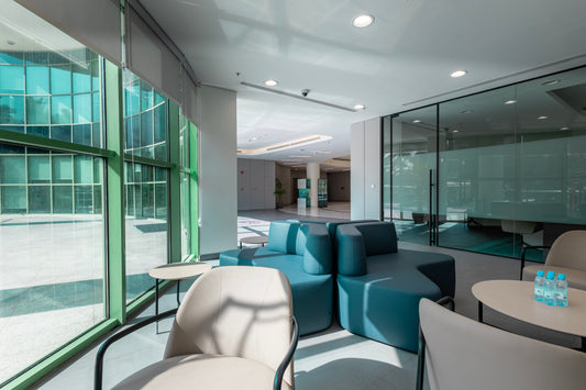 Modern office lounge with teal modular seating, beige chairs, and glass partitions, designed by Atelier 21 KSA – مفن الرسام. Best interior fit-out in Riyadh, top office furniture supplier, top interior designer, افضل شركة تشطيبات داخلية، أفضل مصمم داخلي وأفضل مورد أثاث مكتبي في السعودية 14