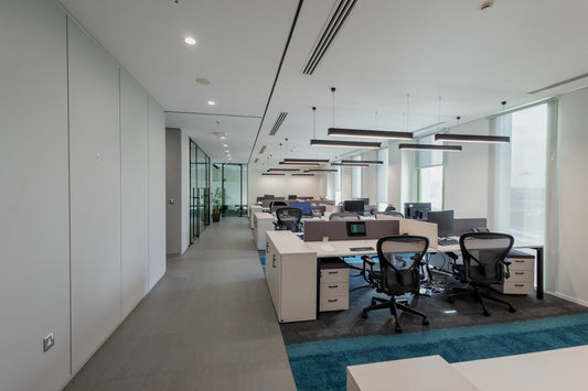 Modern open-plan office workspace with ergonomic chairs, white desks, partitions, and glass walls by Atelier 21 KSA – مفن الرسام, top office furniture supplier, top interior designer, and Best interior fit-out in Riyadh, Saudi Arabia – مساحة عمل مكتبية مفتوحة حديثة تحتوي على كراسي مريحة، مكاتب بيضاء، فواصل زجاجية من مفن الرسام، أفضل مورد أثاث مكتبي وأفضل مصمم داخلي وافضل شركة تشطيبات داخلية في الرياض، السعودية 11
