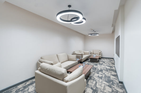 Modern living room with beige sofas, coffee table, and stylish pendant lights by Atelier 21 KSA, top interior designer in Saudi Arabia – غرفة معيشة عصرية تحتوي على كنبات بيج، طاولة قهوة، وإضاءات معلقة أنيقة من مفن الرسام، أفضل مصمم داخلي في السعودية 11