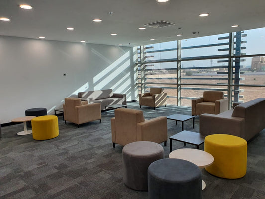 Modern breakout lounge at STC NOC project in Riyadh, furnished by Atelier 21 KSA مفن الرسام. The space features contemporary sofas, armchairs, and colorful poufs for casual meetings or relaxation. أفضل مصمم داخلي في السعودية وأفضل مورد أثاث في الرياض، مع تنفيذ راقٍ من أفضل شركة تنفيذ تشطيبات داخلية، يعكس بيئة عمل مريحة وعصرية تدعم رفاهية الموظفين. 6