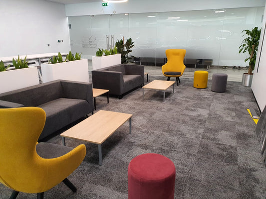 STC NOC Riyadh breakout area furnished by Atelier 21 KSA مفن الرسام with modern sofas, colorful poufs, and coffee tables. This vibrant lounge reflects the work of أفضل مصمم داخلي في السعودية وأفضل مورد أثاث مكتبي في الرياض، من تنفيذ أفضل شركة تنفيذ تشطيبات داخلية في السعودية، لتعزيز بيئة العمل بأسلوب عصري يلائم تطلعات STC. 2