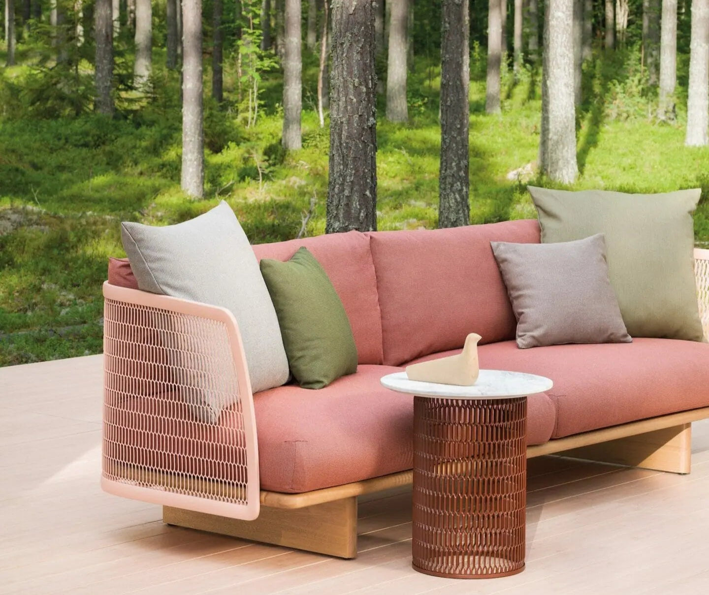 Pink outdoor sofa with cushions in a forest setting